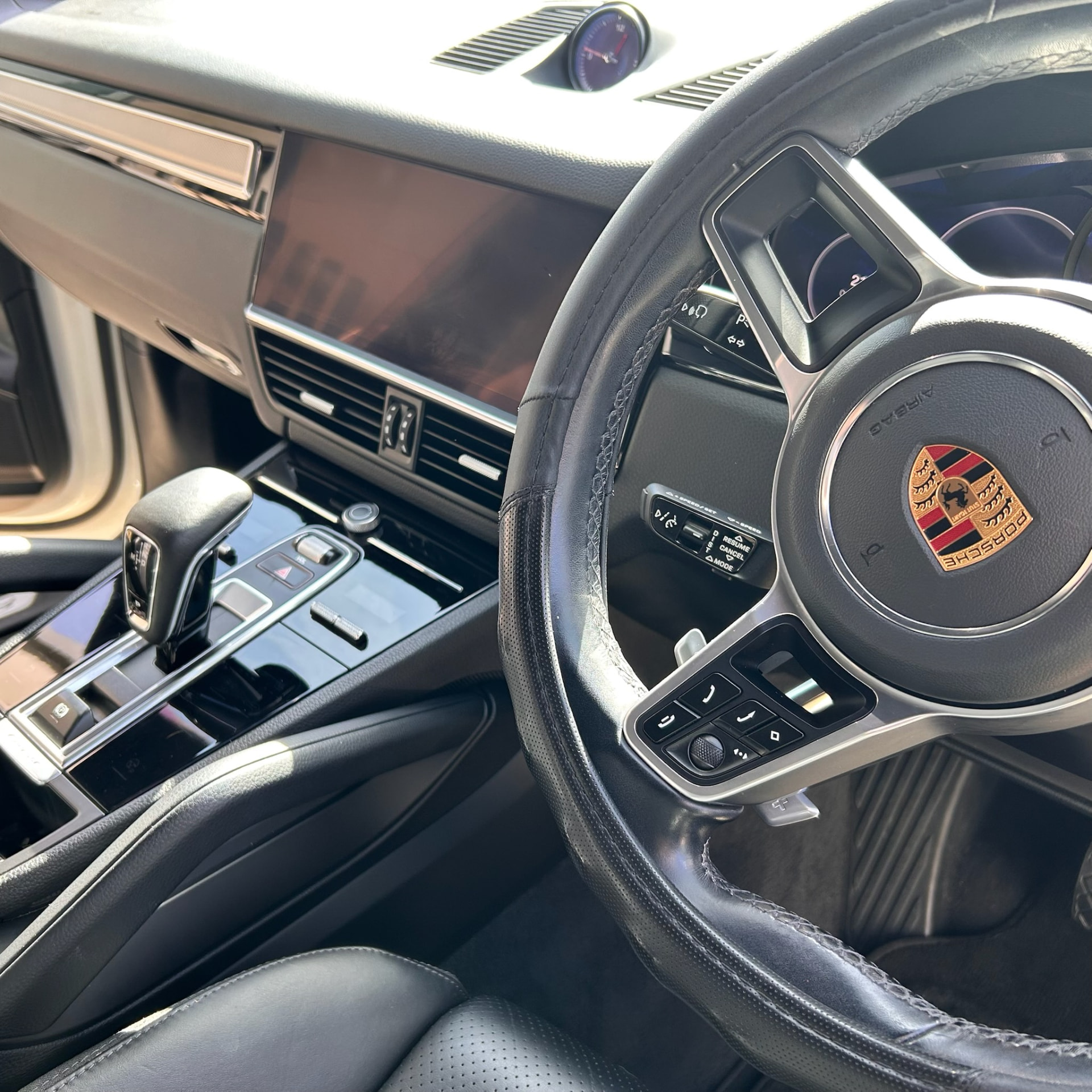 Spotless Porsche cabin with detailed leather steering wheel, console and screen